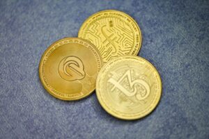 three gold coins sitting on top of a blue surface